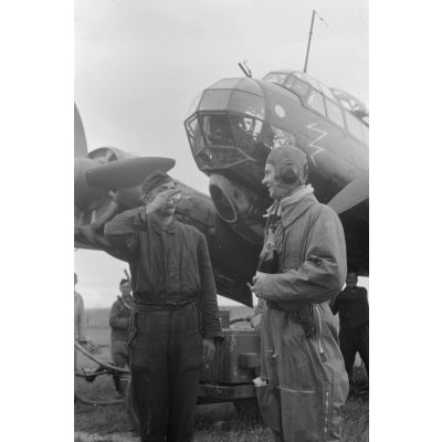Un officier pilote de bombardier Junkers Ju-88 du Kampfgeschwader 3 offre un verre de Champagne à son mécanicien.