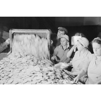 Des femmes russes travaillent dans une buiscuiterie sous le contrôle des contre-maitres allemands.