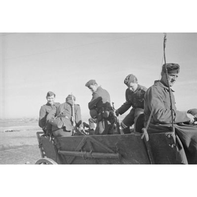 Des fantassins allemands dans une charrette d'infanterie pour se rendre au cimetière.