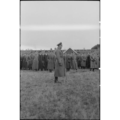 Lors de la démonstration aéroportée du Luftlandegeschwader 1 (8./LLG 1), un officier de la Luftwaffe s'expriment devant un micro et un panel d'officiers de la Wehrmacht.