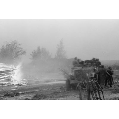 Un semi-chenillé Sd.kfz.7/1 armés de 2 cm FlaKvierling 38 dans un village en feu.