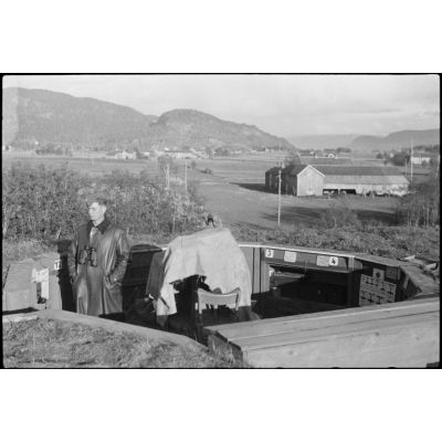 En Norvège, sur un terrain d'aviation (région de Trondheim), un artilleur de la Luftwaffe monte la garde à proximité d'un canon antiaérien de 2 cm Flak 30.