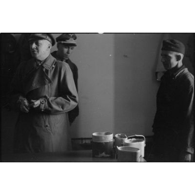 Lors de sa tournée d'inspection auprès du schwere Panzer Abteilung 508, le général Kurt Student goûte à la nourriture dans les cuisines.