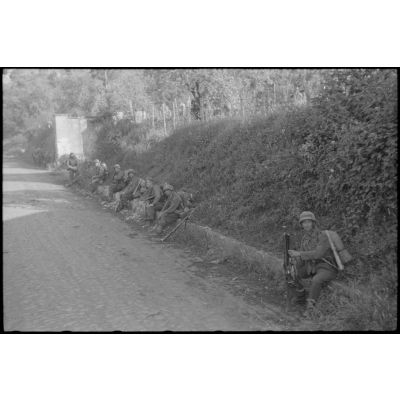 Des fantassins allemands marquent une pause sur une route au sud de Rome.