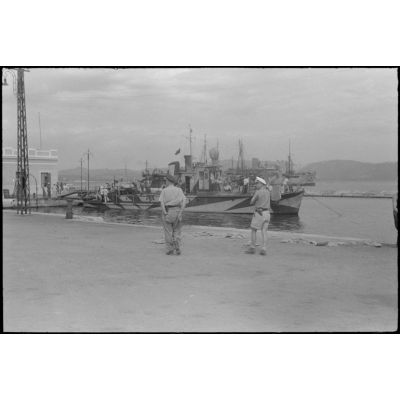 Dans le port de Corfou, déchargement de matériels depuis des péniches de la Kriegsmarine.