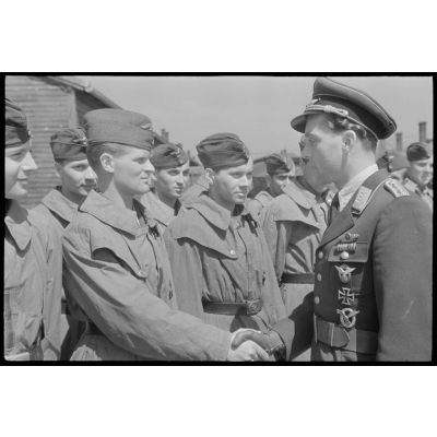 Un capitaine (Hauptmann) du Lehrgeschwader 1 (LG1) passe en revue les aviateurs de son unité avant de les féliciter.
