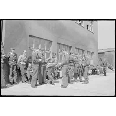 Des sous-officiers du II./Lehrgeschwader I plaisantent devant un baraquement.