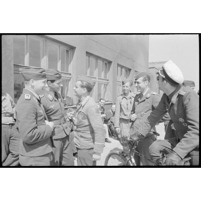 Des sous-officiers du II./Lehrgeschwader I plaisantent devant un baraquement.
