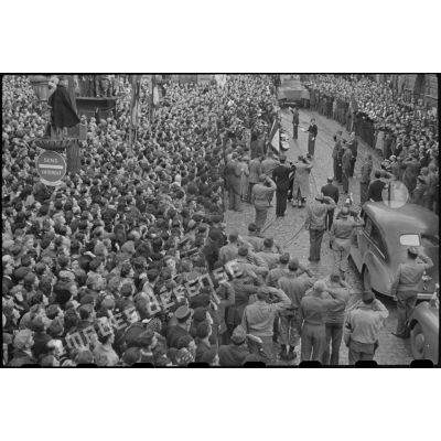 Revue des troupes par le général De Gaulle place Saint-Pierre à Besançon, devant une foule nombreuse.
