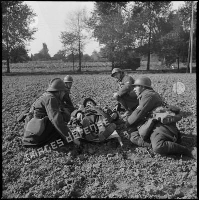 Fantassins du 310e régiment d'infanterie (RI) lors d'un exercice de brancardage, peut-être dans le secteur défensif de Lille.