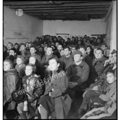 Photographie de groupe de soldats de la 2e armée qui assistent à une séance de cinéma aux armées.
