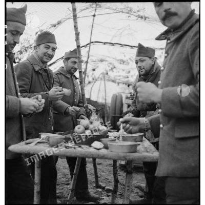Photographie de groupe d'artilleurs du 185e RA qui mangent dehors.