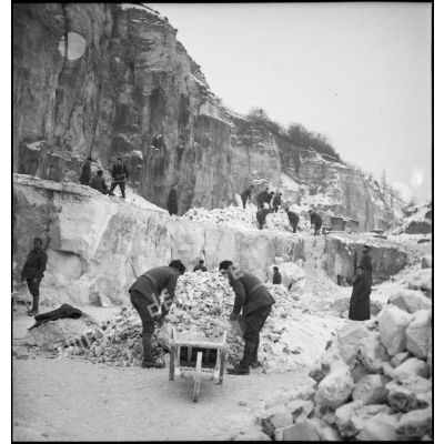 Des pionniers d'une unité de la 55e DI (division d'infanterie) travaillent dans une carrière pour extraire des pierres destinées à la réfection d'une route.