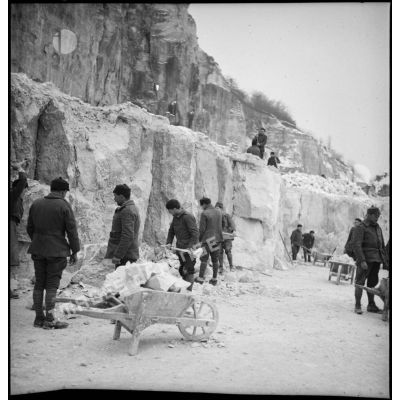 Des pionniers d'une unité de la 55e DI (division d'infanterie) travaillent dans une carrière pour extraire des pierres destinées à la réfection d'une route.