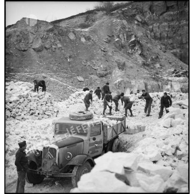 Des pionniers d'une unité de la 55e DI (division d'infanterie) chargent des pierres extraites d'une carrière dans la benne d'un camion Citroën type 45.