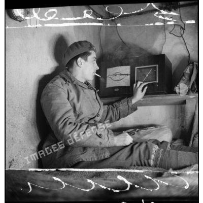 Plan moyen d'un soldat d'un régiment d'infanterie de forteresse (RIF) qui écoute la radio dans une chambrée d'un ouvrage de la ligne Maginot.