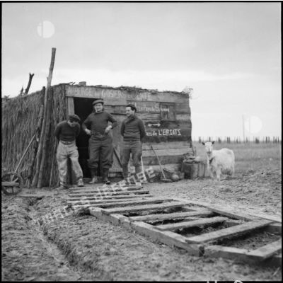 Soldats de la 3e armée posant devant une cagna faisant probablement office de popote.
