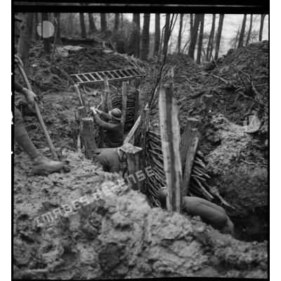 Des soldats de la 4e armée aménagent une tranchée dans un bois.