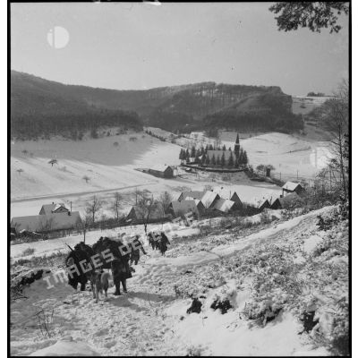 Une patrouille de la 5e armée se déplace dans la neige vers un village alsacien dans la vallée.