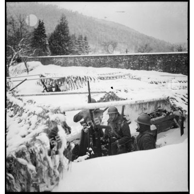 Des soldats de la 5e armée servent une mitrailleuse Hotchkiss M1914 sur affût antiaérien dans la neige.