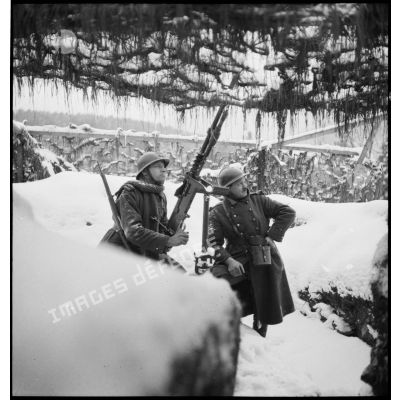 Des fantassins d'une unité de la 5e armée servent une mitrailleuse Hotchkiss Mle 1914  8 mm, sur affût antiaérien près d'un abri.