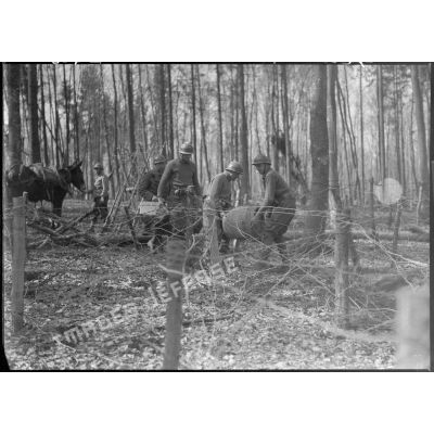 En forêt des soldats de la 5e armée portent des tonneaux de ravitaillement.