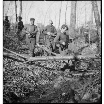 Des soldats d'un corps franc de la 5e armée se déplacent en patrouille dans une forêt.