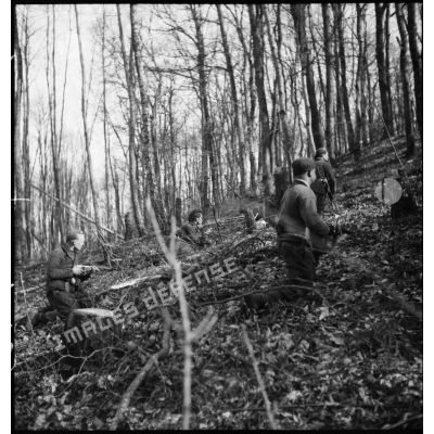 Des soldats d'un corps franc de la 5e armée se déplacent en patrouille dans une forêt.