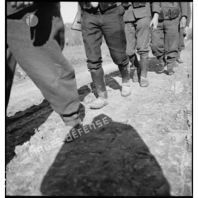 Plan rapproché des pieds de soldats de la 5e armée qui marchent en colonne.