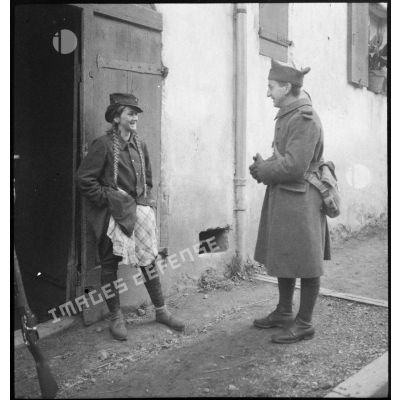 Soldat de la 8e armée discutant avec une jeune habitante d'un village viticole d'Alsace.