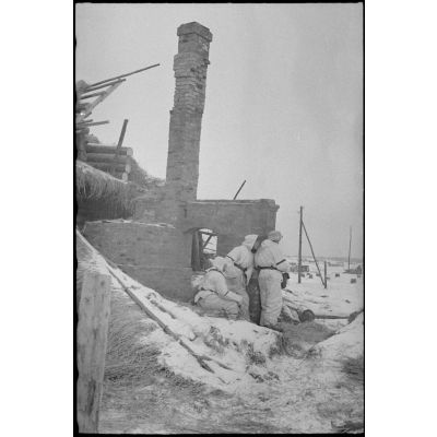 Des fantassins allemands derrière les ruines d'une maisondurant la bataille de Witebsk.
