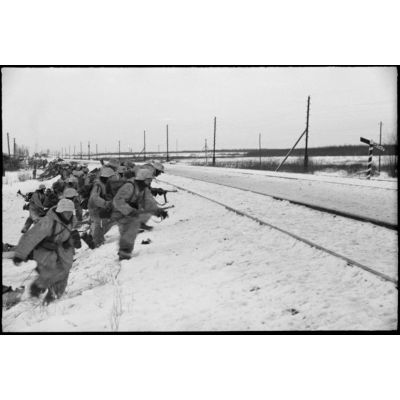 Retranchés derrière une voie ferrée, des fantassins allemands (Jäger) partent à l'assaut de positions ennemies.