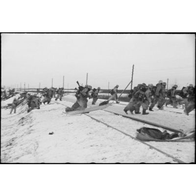 Retranchés derrière une voie ferrée, des fantassins allemands (Jäger) partent à l'assaut de positions ennemies.