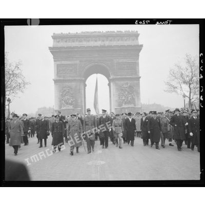 Défilé du général de Gaulle et de Winston Churchill, suivis du cortège officiel, sur les Champs-Elysées lors de la cérémonie du 11 Novembre 1944 à Paris.