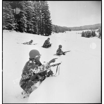 Tirailleurs sénégalais de la 9e DIC (division d'infanterie coloniale) progressant dans la forêt des Vosges enneigée, armés de pistolets-mitrailleurs Thompson M1A1 et de fusils Springfield M1903.