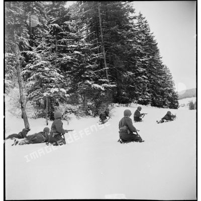 Tirailleurs sénégalais de la 9e DIC (division d'infanterie coloniale) progressant dans la forêt des Vosges enneigée, armés de pistolets-mitrailleurs Thompson M1A1 et de fusils Springfield M1903.
