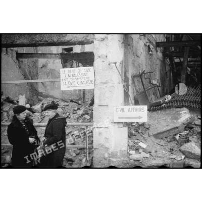 Habitantes dans une rue de Metz endommagée lors des combats de libération de la ville entre le 20 et 22 novembre 1944 par le 20e Corps d'armée américain.