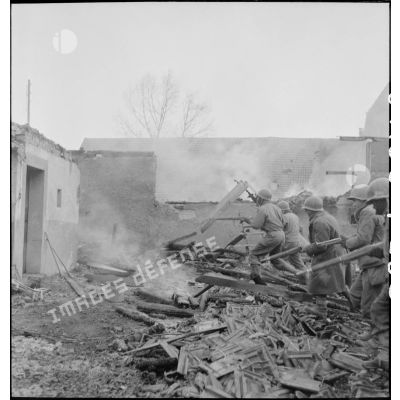 Fantassins du CC4 (Combat command n°4) de la 5e DB, armés de fusils (Springfield M1903 A3A4 ?) à l'assaut de la commune de Dannemarie (Haut-Rhin) en ruine.