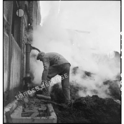 Habitant de Dannemarie, tentant d'éteindre un incendie provoqué par les combats menés par la 5e DB (division blindée) pour reconquérir la commune.