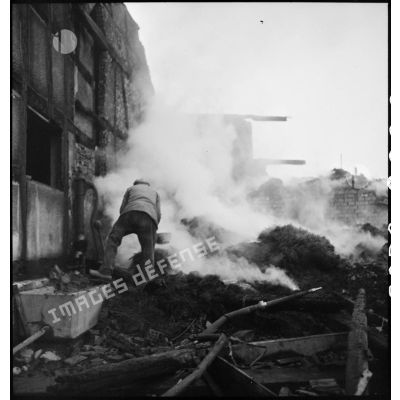 Habitant de Dannemarie, tentant d'éteindre un incendie provoqué par les combats menés par la 5e DB (division blindée) pour reconquérir la commune.