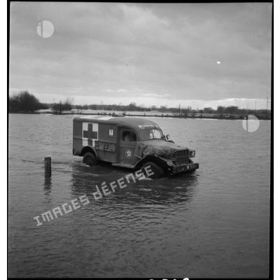 Le Dodge ambulance Cornebiche de la 2e DB traverse une zone inondée aux abords de l'Ill.