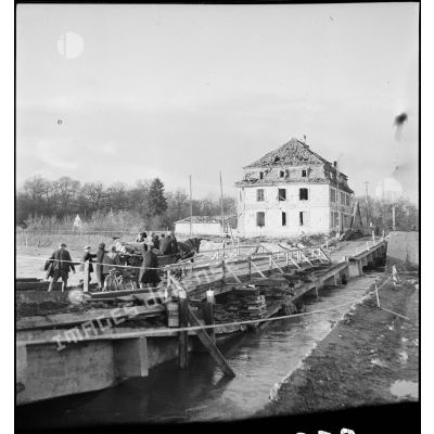 Des réfugiés empruntent un pont provisoire au-dessus du canal de décharge de l'Ill à Krafft (Bas-Rhin).