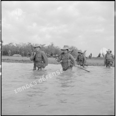 Progression d'éléments du bataillon de marche indochinois (BMI) à travers les rachs, de l'eau jusqu'à la taille, au cours de l'opération Marécages au nord d'Haïduong.
