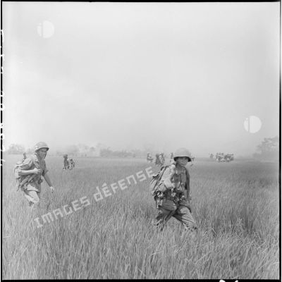 Progression d'éléments du 2e BEP (bataillon étranger de parachutistes) dans les rizières enfumées par un incendie.