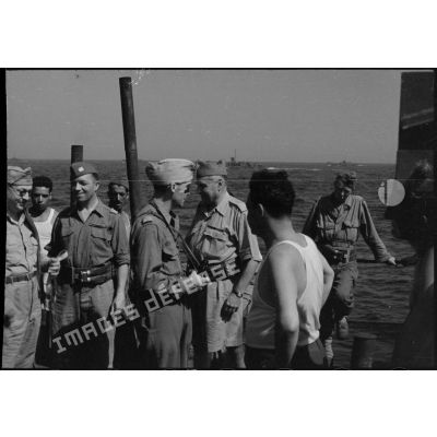 Partis de Naples, des officiers français et américains du 1er Corps d'armée à bord d'un transport de troupes font route pour la France en vue du débarquement allié sur les côtes de Provence (opération Anvil-Dragoon) en août 1944.