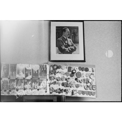 Album d'insignes nazis et portrait d'Adoff Hitler dans l'appartement d'un officier allemand investi par le 12e régiment de cuirassiers (12e cuirs) de la 2e division blindée (2e DB) près du pont de Kehl (Bas-Rhin).