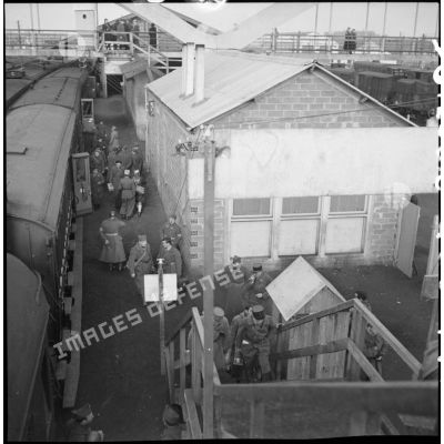Plan d'ensemble, en plongée d'un quai de la gare de Massy où des permissionnaires descendent d'un train.