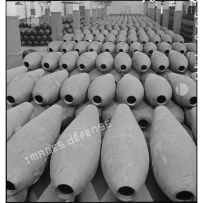 Plan général d'enveloppes de bombes alignées et rangées dans un atelier de l'usine de munitions.