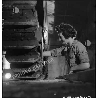 A l'atelier d'Issy-les-Moulineaux une ouvrière travaille sur le train de roulement d'un char Renault R40.