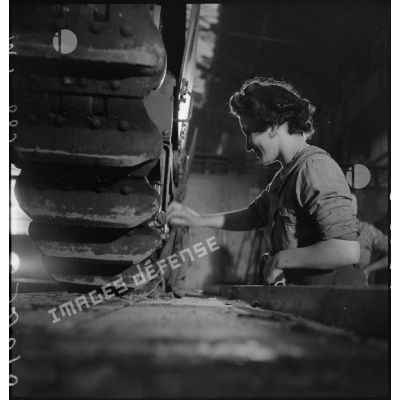 A l'atelier d'Issy-les-Moulineaux une ouvrière travaille sur le train de roulement d'un char Renault R40.